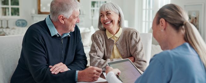 Happy, old couple and caregiver in home