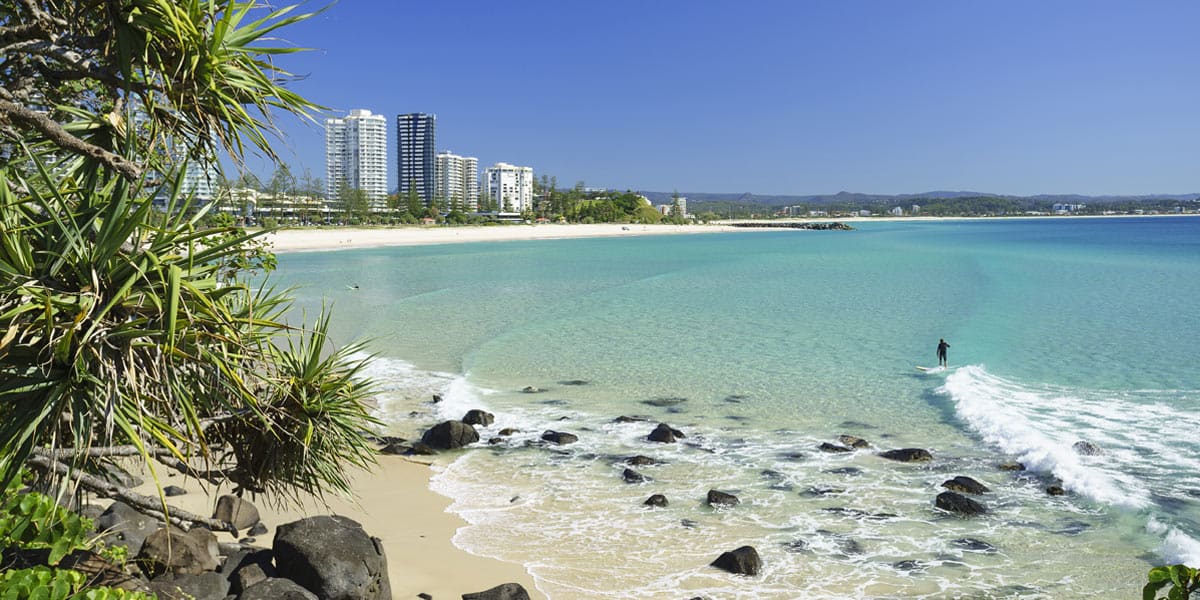 Direct Cremation Gold Coast Clear Pricing and Care Coolangatta Beach with clear blue water, sandy shoreline and high-rise buildings in the distance.
